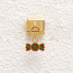 Macro shot of gold Italian charm link with a red and green enamel candy pendant