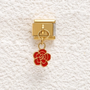 Macro detail of Italian charm with gold stainless steel base and red enamel rose pendant
