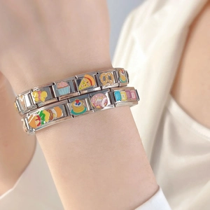 Nahaufnahme des modularen Edelstahlarmbands mit Emaille-Pizza-, Schmetterlings- und Baby-Charms