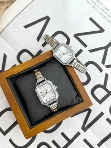 Detail view of silver square quartz watches with rhinestone bezel on a wooden gift box