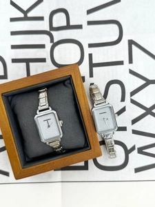 Detail of elegant rectangular silver quartz watch with shimmering dial in wooden gift box
