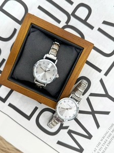 Close-up of silver quartz watch with Arabic numerals and elegant wooden gift box