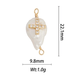 Detailed macro of baroque pearl pendant with gold cross inlay and zircon stone accents