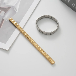 Dettaglio di bracciali modulari Italian Charm in oro e argento con motivi a stella incisi