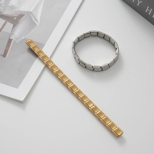 Vista dettagliata dei braccialetti modulari in acciaio inossidabile oro e argento su bianco