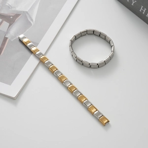 Dettaglio di bracciali modulari italiani in acciaio inossidabile bicolore argento e oro