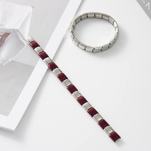 Dettaglio di bracciali modulari in acciaio inossidabile con maglie argento e bordeaux