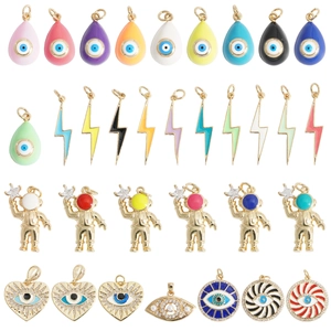 Detailed macro view of assorted gold-plated Evil Eye and astronaut DIY jewelry charms