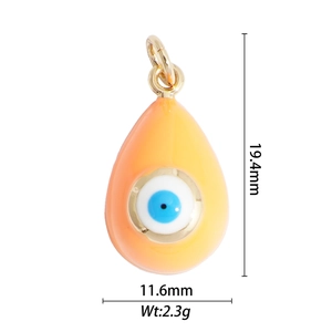 Detail view of water drop evil eye pendant in orange enamel with gold base specs