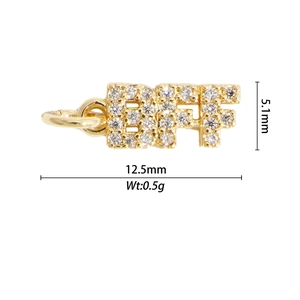 Détail macro du pendentif lettres BFF en cuivre doré serti de zircons blancs brillants
