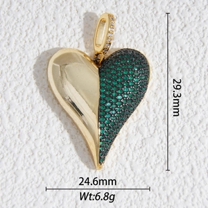 Detalle de colgante de corazón asimétrico con pavé de circonitas verdes y baño de oro