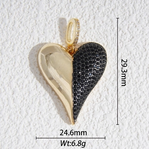 Detalle macro del colgante de corazón asimétrico con piedras negras y baño de oro