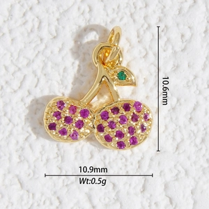 Vue détaillée du mini pendentif cerise avec cristaux roses et feuille verte sur blanc