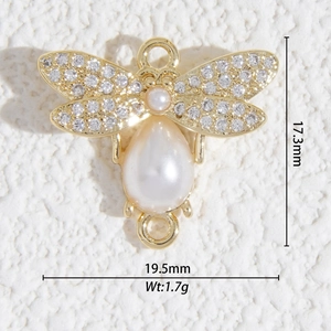 Vue macro montrant les dimensions d'un connecteur de bijoux insecte doré avec perles