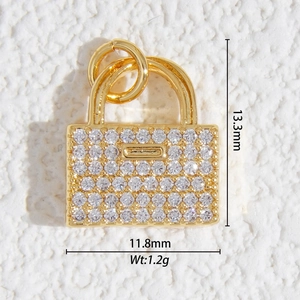 Vue macro d'un pendentif doré avec zircons montrant 13,3 mm de haut et 11,8 mm de large