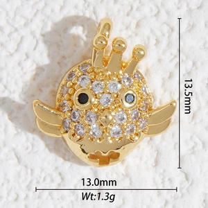 Gros plan d'un pendentif oiseau doré de 13,5mm serti de zircons et d'yeux en pierres bleues