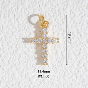 Détail macro d'un pendentif croix dorée avec zircons sur une surface en pierre blanche