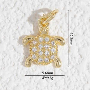 Vue macro d'un pendentif tortue en or avec zircons blancs et dimensions précises
