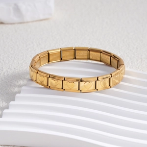 Close-up of golden stainless steel modular links with embossed heart patterns on white stand