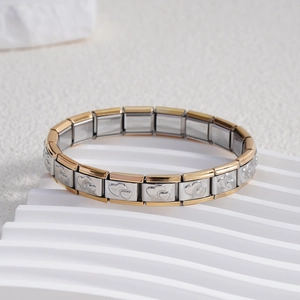 Detail view of gold and silver stainless steel modular bracelet with heart engravings