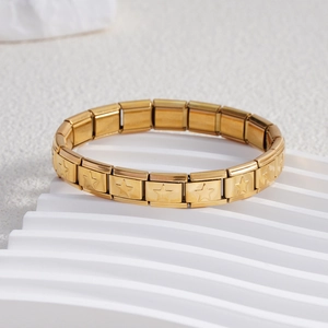Macro detail of gold stainless steel Italian charm bracelet with engraved star pattern
