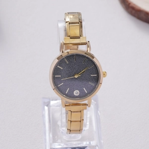 Detailed macro view of the gold quartz watch with a dark grey starry sky dial and rhinestones