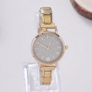Detail view of a gold fashion watch with a sparkling silver dial and rhinestone marker