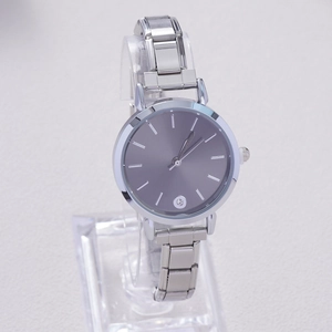 Macro detail of silver quartz watch with grey dial, crystal marker, and link bracelet
