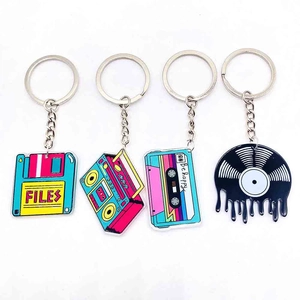 Detailed view of four retro acrylic keychains with radio, cassette, and vinyl record shapes