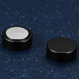 Detail view of round black magnetic titanium steel earrings with silver magnet backing