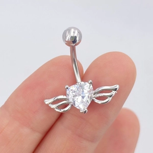 Bauchpiercing aus Edelstahl mit herzförmigem Zirkon und Metallflügeln in der Hand gehalten
