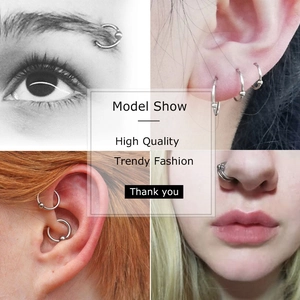Macro detail of stainless steel BCR body rings worn on eyebrow, nose and ear cartilage