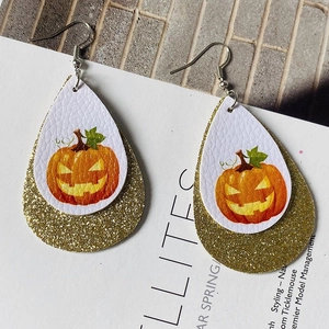 Close-up of double-layered Halloween pumpkin faux leather teardrop earrings with gold glitter