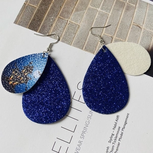 Detail of glitter navy waterdrop earrings with western cowboy leather pattern and silver hooks