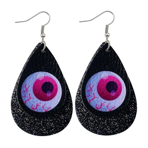 Detail of Halloween drop earrings showing textured eyeball print and black glitter layers