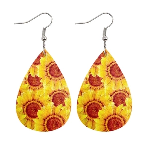 Close-up of teardrop leather earrings featuring vibrant sunflower prints and silver hooks