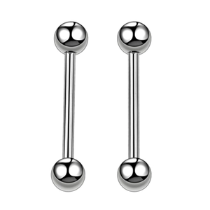 Détail macro de piercings barbell en acier inoxydable poli avec embouts sphériques