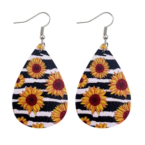 Detailed view of teardrop leather earrings with yellow sunflowers and black stripes