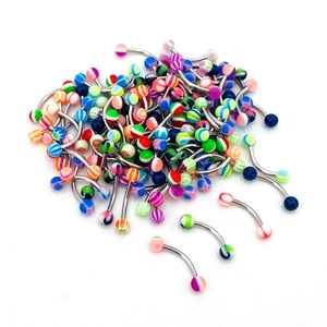 Macro view of assorted acrylic curved barbell piercings with colorful striped balls
