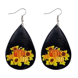 Détail de boucles d'oreilles en cuir en forme de larme avec motif de citrouille d'automne