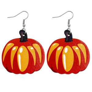 Gros plan de boucles d'oreilles citrouille en similicuir avec textures dégradées de récolte