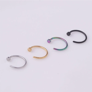 Detail of C-shaped stainless steel nose rings in silver, gold, rainbow and black finishes