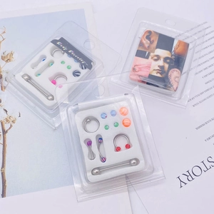 Détail d'un kit de piercing corporel avec barres en acier et billes en acrylique coloré
