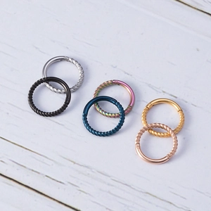 Detail of twisted rope design seamless clicker rings in six diverse metallic colors