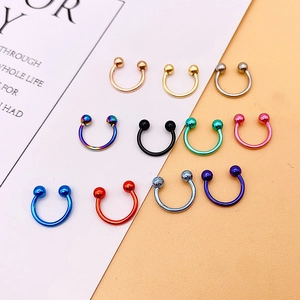 Detailed display of ten different colored stainless steel C-shaped horseshoe nose rings