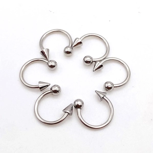 Polished stainless steel circular barbells with ball and spike ends in a radial arrangement