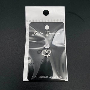 Détail du piercing de nombril en acier chirurgical avec pendentif cœur et zircon