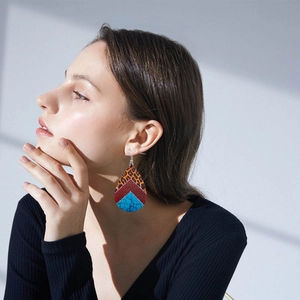 Boucles d'oreilles bohèmes en cuir avec motif léopard et texture turquoise sur modèle