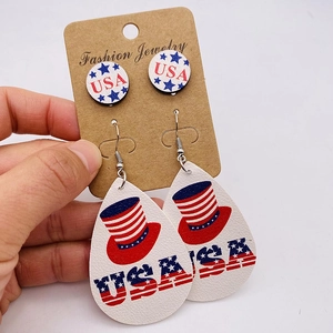 Detail of USA flag earrings set with red white blue stars and stripes on leather