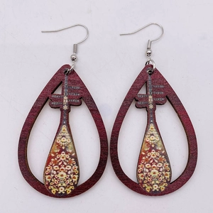 Detailed shot of teardrop wood earrings with hollow lute design and ethnic patterns